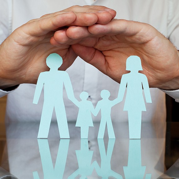 Hands covering a paper cut out family