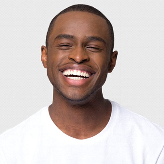 Smiling man on white background with veneers in Fort Worth