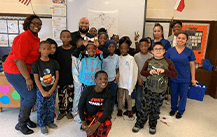 Dental team member with group of kids at school event