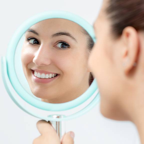 Woman looking at smile during dental treatment visit