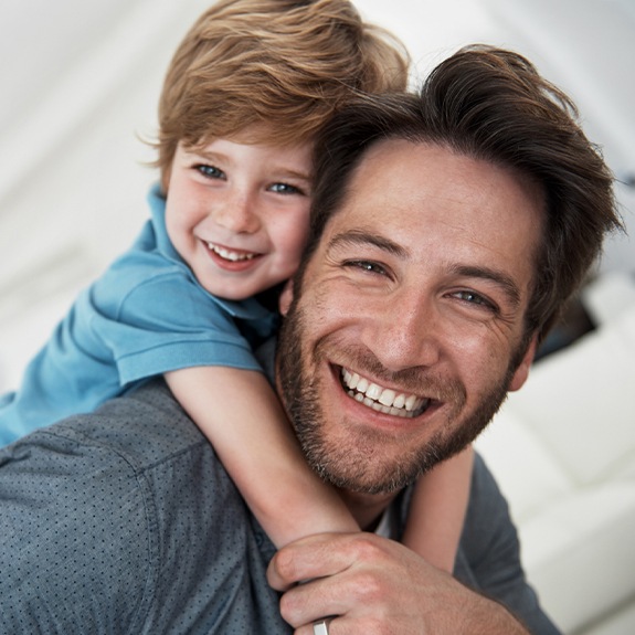 Young boy and father smiling after children's dentistry visit