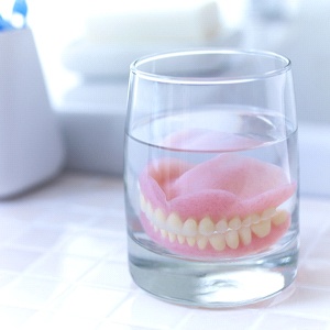Full dentures in Fort Worth soaking in glass