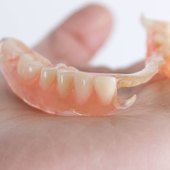 Hand holding a partial denture