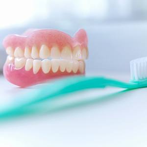Dentures sitting next to a toothbrush