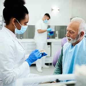 A dentist explaining denture care to a patient