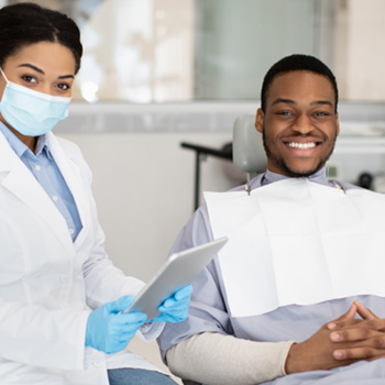 Patient smiling treatment chair next to dentist