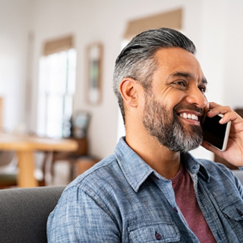 Man smiling while talking on phone 