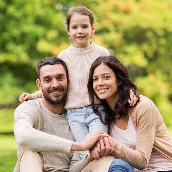 Family of three smiling after visiting their dentist in Fort Worth