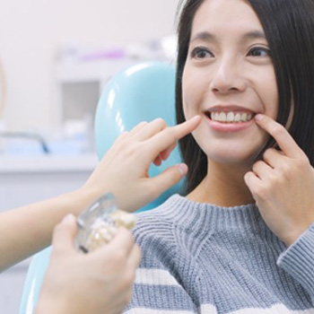 Patient smiling as dentist examines her teeth
