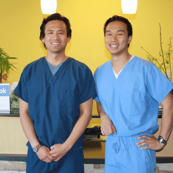 Two dentists at dental office reception desk