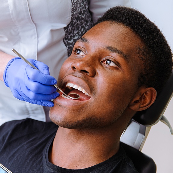 Man receiving dental checkup and teeth cleaning