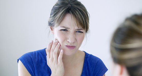 Man in need of emergency dentistry holding jaw