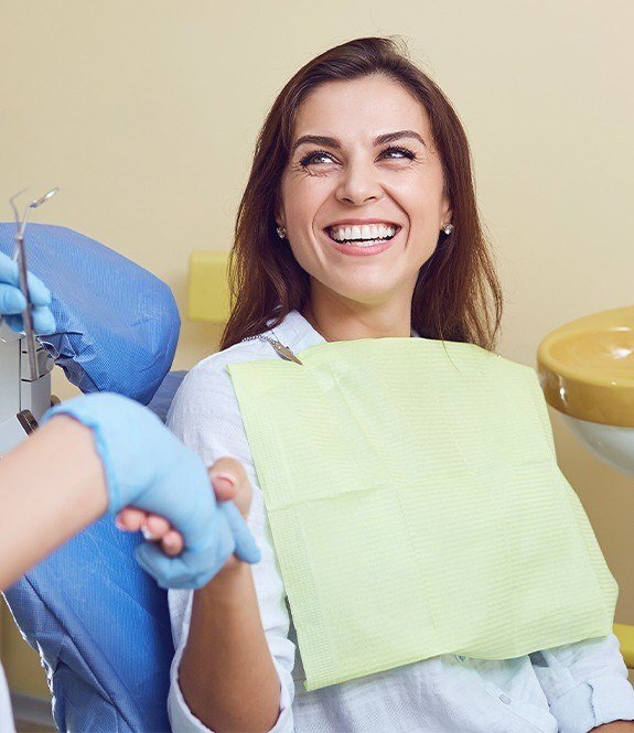 Smiling woman shaking hands with dentist