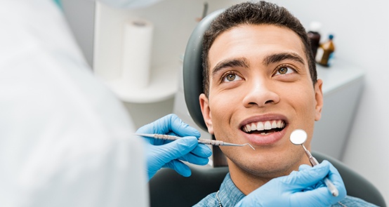 Dentist examining man's smile during preventive dentistry checkup