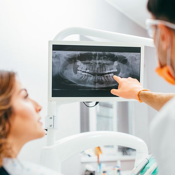 Dentist and patient looking at all digital dental x-rays