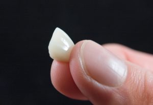 Dental crown held in fingertips 