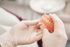 Pair of hands holding dentures. 